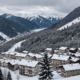 A snowy landscape in Abetone, Italy, showcasing a winter wonderland with trees and houses covered in snow.