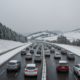 Snow in Tuscany, cars in traffic on a highway, winter season