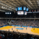 A lively indoor sports arena filled with enthusiastic fans, showcasing the energy of a volleyball game.
